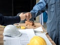 Business, building, teamwork, gesture and people concept - group of smiling builders in hardhats greeting each other with Hand