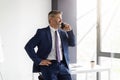 Business Call. Confident Middle Aged Businessman Talking On Cellphone At Office Royalty Free Stock Photo