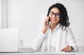 Latin businesswoman talking on phone and writing Royalty Free Stock Photo