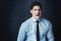 Business can have you going insane sometimes. Studio portrait of a young businessman making a face against a dark Royalty Free Stock Photo