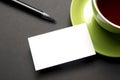 Business card blank over coffee cup and pen at office table. Corporate stationery branding mock-up Royalty Free Stock Photo