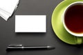 Business card blank over coffee cup and pen at office table. Corporate stationery branding mock-up Royalty Free Stock Photo