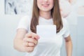 Business card or gift card. Blurred Happy and excited caucasian woman in casual clothes showing focused blank empty paper card Royalty Free Stock Photo