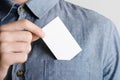 Business Card Mock-Up 85x55mm - Man in a chambray shirt holding a blank card on a gray background Royalty Free Stock Photo