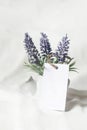 Business card mockup with lavender flowers on white background.