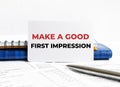 Business card with text Make a good first impression lying on blue notebook Royalty Free Stock Photo