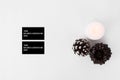 Business cards christmas composition. stylish arrangement of cones and candle on white background. flat lay top view.