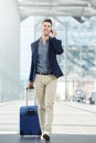 Business casual man on phone call in station with suitcase Royalty Free Stock Photo