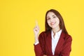 Business Caucasian woman in red suit smiling and thinking for good idea on yellow background Royalty Free Stock Photo