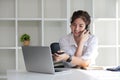 Business Caucasian woman Talking on the phone and using a laptop with a smile while sitting at modern office Royalty Free Stock Photo