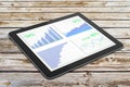 Business chart on digital tablet screen on wooden table Royalty Free Stock Photo