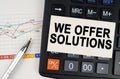 On the business chart lies a pen, a calculator and a business card with the inscription - We Offer Solutions Royalty Free Stock Photo