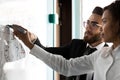 Business coach training African American employee, drawing on flip chart