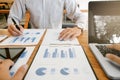 Business colleague working on report documents with laptop at a workplace Royalty Free Stock Photo