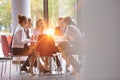 Business colleagues discussing while sitting at table in office lobby during meeting Royalty Free Stock Photo