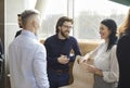 Business colleagues having fun chatting and discussing work in casual conversation in office. Royalty Free Stock Photo