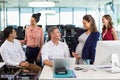 Business colleagues interacting with each other at desk in office Royalty Free Stock Photo