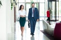 Business colleagues interacting with each other while walking in the corridor at office Royalty Free Stock Photo