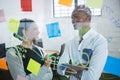 Business colleagues interacting with each other while writing on sticky note Royalty Free Stock Photo