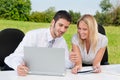 Business colleagues in nature with laptop smile Royalty Free Stock Photo