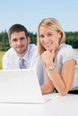 Business colleagues in nature with laptop smile Royalty Free Stock Photo