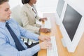 Business colleagues using computers at desk