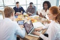 Business colleagues using laptop and digital tablets around breakfast table Royalty Free Stock Photo