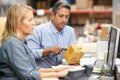 Business Colleagues Working At Desk In Warehouse Royalty Free Stock Photo