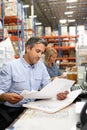 Business Colleagues Working At Desk In Warehouse Royalty Free Stock Photo