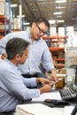 Business Colleagues Working At Desk In Warehouse Royalty Free Stock Photo