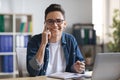 Business Communication. Male Office Employee Talking On Cellphone And Taking Notes Royalty Free Stock Photo