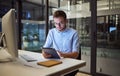 Business, communication and overtime, man with tablet and computer at desk. Late night at office, working on deal or Royalty Free Stock Photo