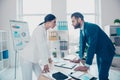 Business competition, side view profile of two colleagues in classy suits having disagreement and conflict, standing in modern Royalty Free Stock Photo