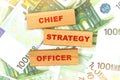 Against the background of euro bills, the text is written on wooden blocks - chief strategy officer