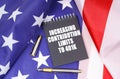 On the American flag lies a pen and a notebook with the inscription - increasing contribution limits to 401k