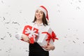 Business Concept - Beautiful young caucasian business woman with santa hat holding gift box with confetti celebration Royalty Free Stock Photo