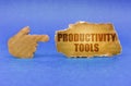 On a blue surface, a cardboard hand points to a sign with the inscription - Productivity Tools Royalty Free Stock Photo