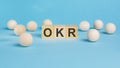 business concept. on the blue table wooden balls and wooden cubes with the inscription - OKR - Objectives and Key Royalty Free Stock Photo