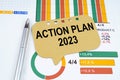 On the business charts is a pen and a sign with the inscription - Action Plan 2023