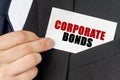 Businessman holds a card with the text - CORPORATE BONDS