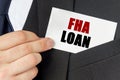 Businessman holds a card with the text - FHA LOAN