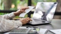 Business concept, Businesswoman holds receipt to checking expense of project and typing on laptop Royalty Free Stock Photo