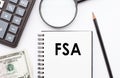 Business Concept: Calculator, Pen, Magnifying Glass, and Notebook on FSA Background Royalty Free Stock Photo
