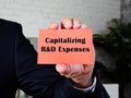 Business concept about Capitalizing R&D Expenses with inscription on the sheet Royalty Free Stock Photo