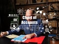 Business concept about Chart of Accounts with inscription. Young businessman reading paperwork at desk in office on background