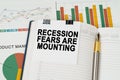 On the business charts is a notepad with the inscription - Recession fears are mounting