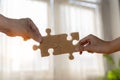 Business concept. Close up of hands connecting two pieces of jigsaw puzzle over the beautiful sunset Royalty Free Stock Photo