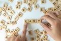 Business Concept. Closeup of man hand make complete EASY wording with other English letters blocks on white background