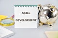 Business concept. The conceptual phrase SKILL DEVELOPMENT in a notebook on a gray background, front view