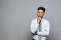 Business Concept - Confident professional african american businessman in thinking posture over grey background Royalty Free Stock Photo